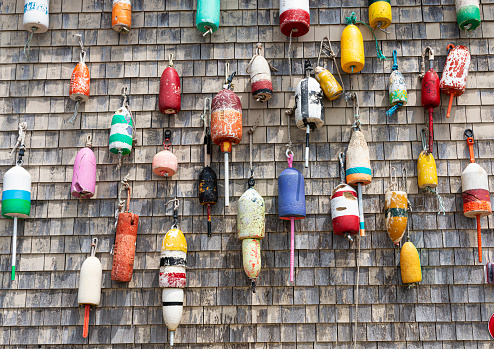 A building in Maine has many colorful lobster buoys hanging on the side in Portland Maine.