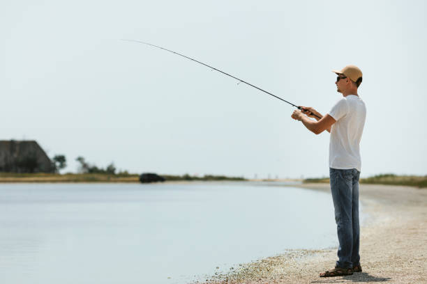 istock Young man fishing at sea 1175933101