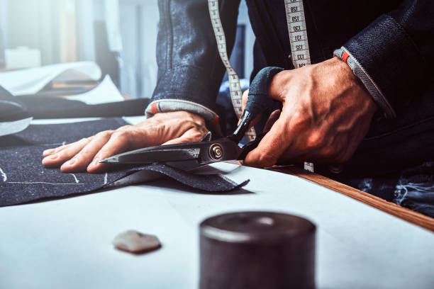 istock Fashion designer is cutting off fabric  with scissors. 1175933994