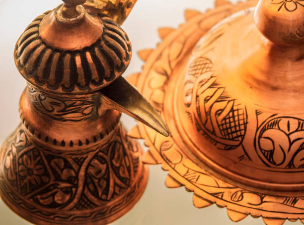 istock Turkish copper coffee pot handmade with embossing and Turkish candy with a national pattern are on the glass table 1175935429