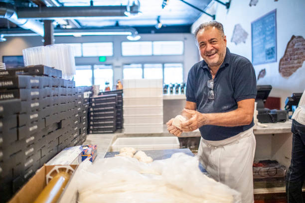senior italian man working pizza dough - pizzeria foto e immagini stock