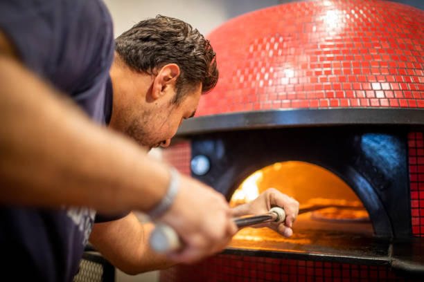 istock Putting Pizzas in the Brick Oven 1175936759