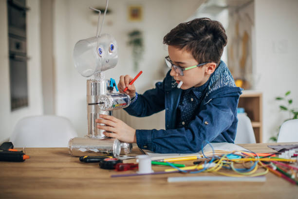 Boy making robot toy of recycling material
