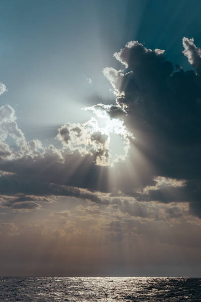 istock Sun breaking through the clouds on the sea 1175939633