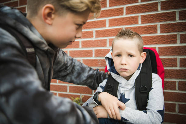 istock boy problem at school, sitting and consoling child each other 1175942870