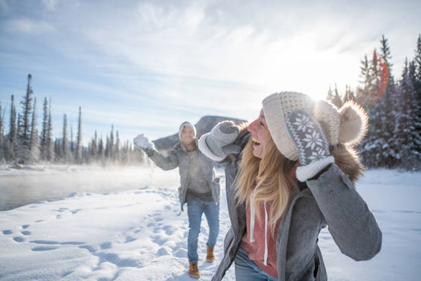 istock Playful couple snowball fighting in winter 1175943630