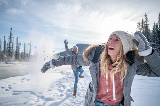 istock Playful couple snowball fighting in winter 1175943683