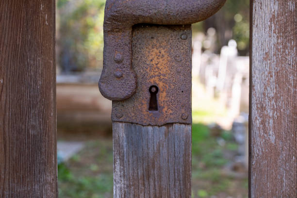 istock Rustic rusty keyhole. Old historic wooden gate with metal lock close up. Medieval, tarnished gate lock. Detail of old Middle Ages gate. 1175943738