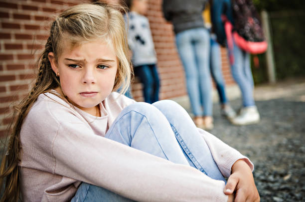 triste momento di intimidazione elementary age bullismo a schoolyard - bullying sneering rejection child foto e immagini stock