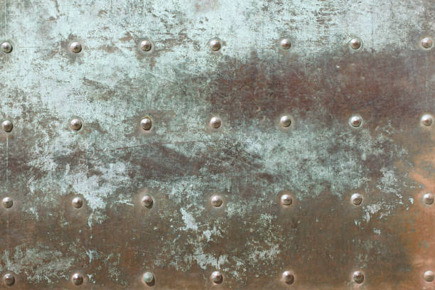 istock Very old, heavy iron door close up surface. Tarnished, rusty metal texture with rivets pattern. Grunge green patina medieval door. Copper Bronze patina background. 1175944301