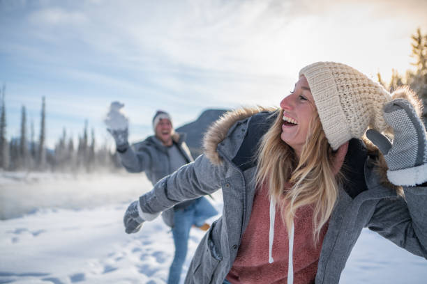istock Playful couple snowball fighting in winter 1175944452