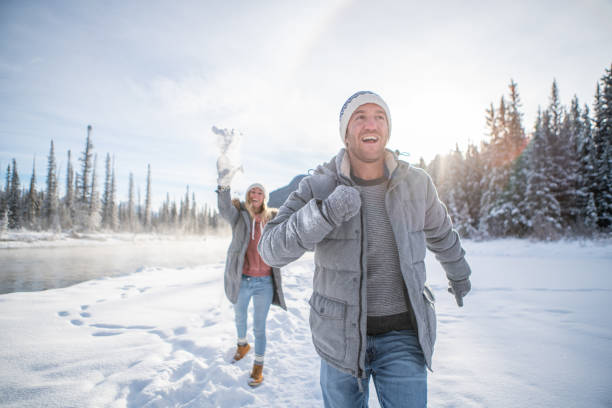 istock Playful couple snowball fighting in winter 1175945146