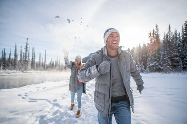 istock Playful couple snowball fighting in winter 1175946314