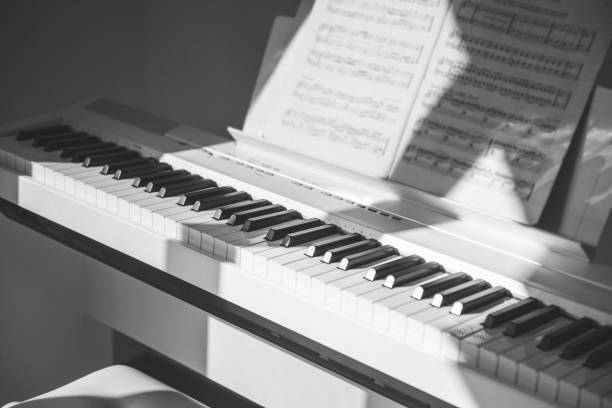 Foto do close up do piano branco eletrônico em casa - foto de acervo