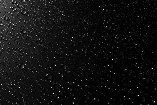 istock Glass with rain drops against dark background 1175948980