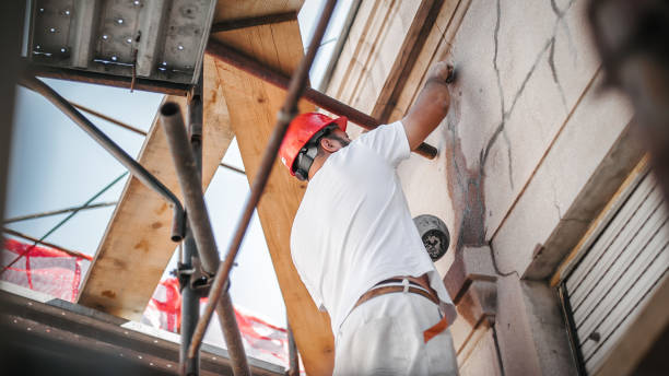 Man worker standing on scaffolding and restore old building facade Man worker standing on scaffolding, perform work on the restoration of the facade of the old building. Repairing and renovate wall renovation stock pictures, royalty-free photos & images