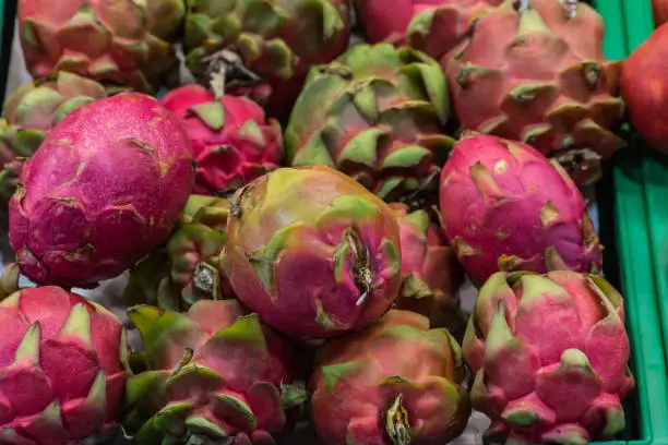 A bunch of exotic fruits basket in supermarket, first-person view, closeup