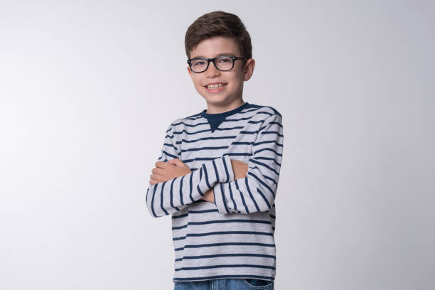 A portrait of a young smiling boy in striped shirt on the white background