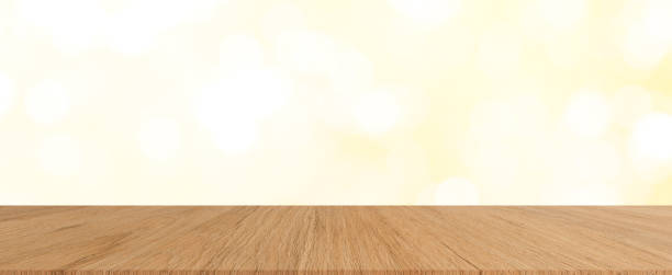 istock abstract blur beautiful soft yellow color circle bokeh light background with modern brown wood tabletop for show,ads,design product on display in the christmas festival and happy new year season concept 1175955802