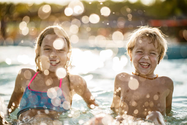 istock Happy boy and girl in the pool 1175960198
