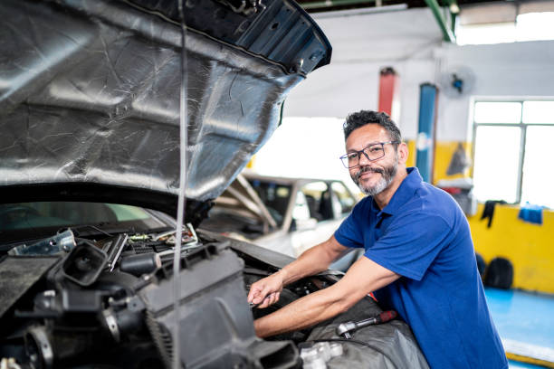 Portrait of a man repairing a car in auto repair shop Portrait of a man repairing a car in auto repair shop car portrait men expertise stock pictures, royalty-free photos & images