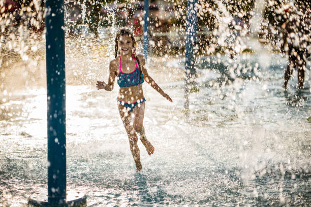 istock Beauty small girl running through falling water 1175960437