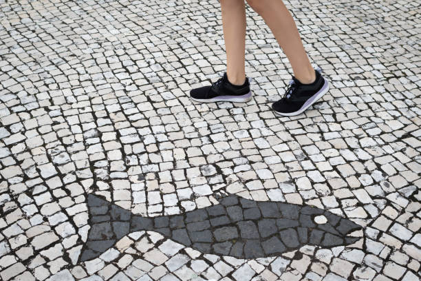 Stone abstract textured background with mosaic ornaments. Unidentified female legs in background stock photo