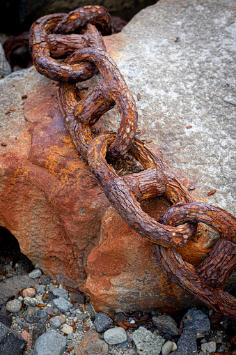 Rusty links of giant chain on stone background. Very heavy and rusting vessel chain