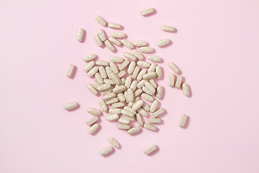 Pills on soft pink background with copy space