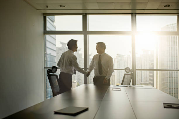 istock Young Chinese Businessman Shaking Hands with Company CEO 1175963995