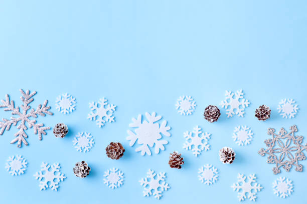 istock Flat lay christmas border with snowflakes and cones on a blue background 1175965332