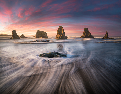 This is a photograph of Silky sea streaks and sea stacks line up at dawn