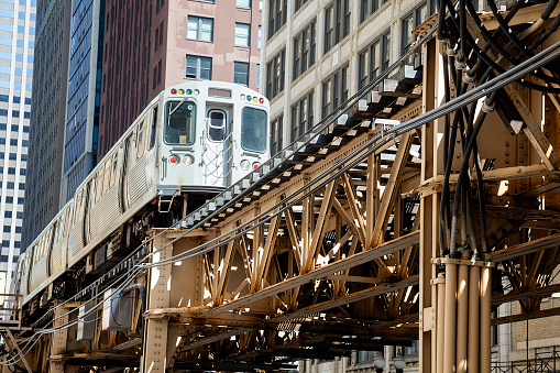 Train approaching  elevated subway station in Chicago. Financial buildings and skyline are seen in the background, USA.