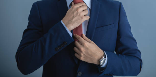istock businessman in suit straightens tie 1175969076