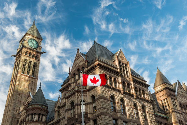City Hall The Canadian flag flies before the Old City Hall in Toronto, Canada. historic building stock pictures, royalty-free photos & images
