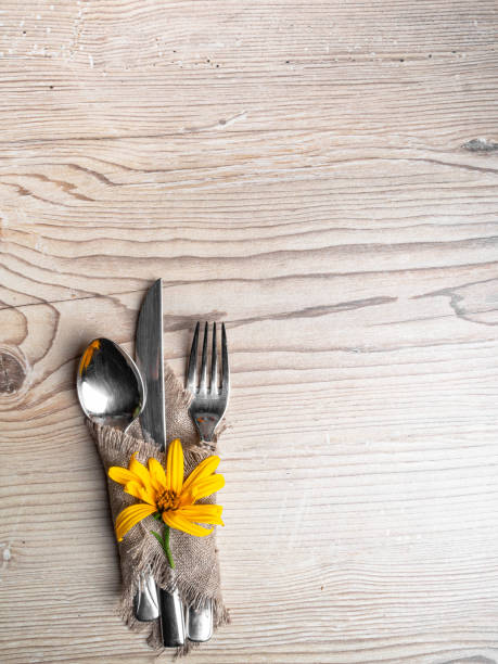 istock Rustic table setting with linen napkin, cutlery, yellow lower on wooden table. Holiday table decoration. Romantic dinner. 1175977716