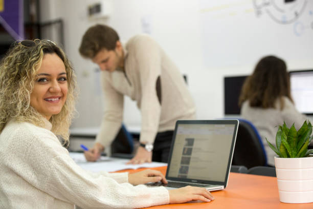 istock Smiling colleagues working together at desk in office 1175980627