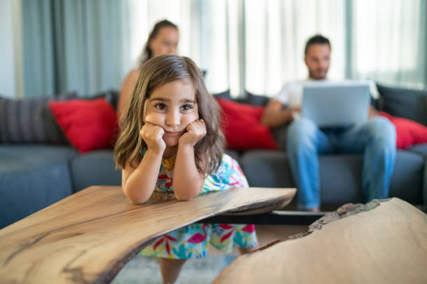 verticale de garçon de tristesse avec sa mère et père avec la fille ennuyée utilisant l'ordinateur portatif sur le sofa. - ignoring photos et images de collection