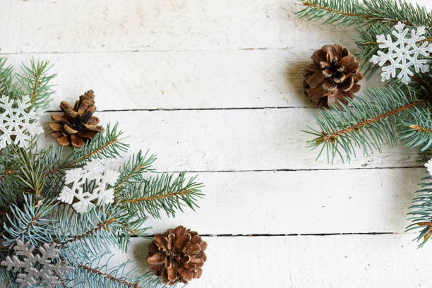 istock Christmas frame with fir branches, pine, snowflackes on a white wood background 1175983272
