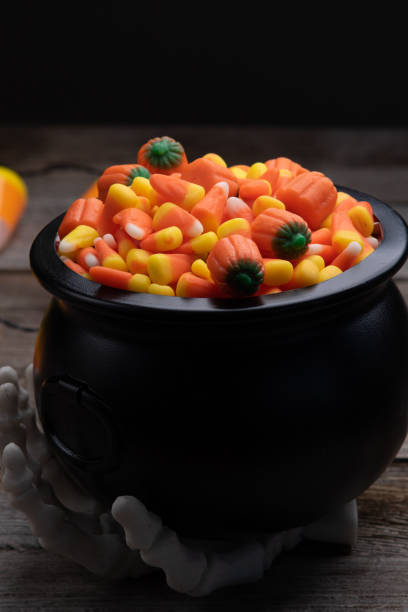 istock Halloween candy in a black cauldron with a skeletal hand 1175984315