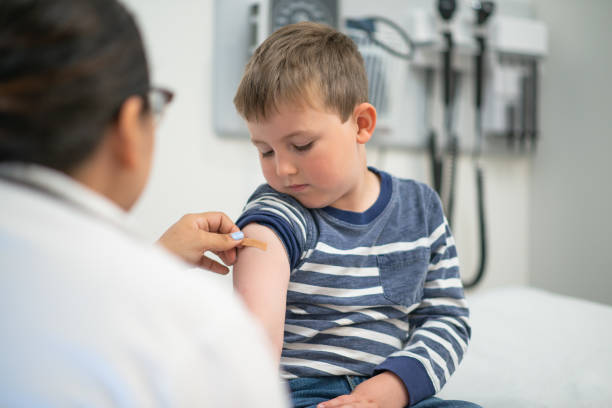 istock Boy gets a shot and bandaid from his doctor 1175995290