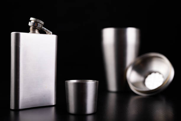 istock Hip flask and stainless steel shaker. Bartender accessories on the table. Black background. 1175996608
