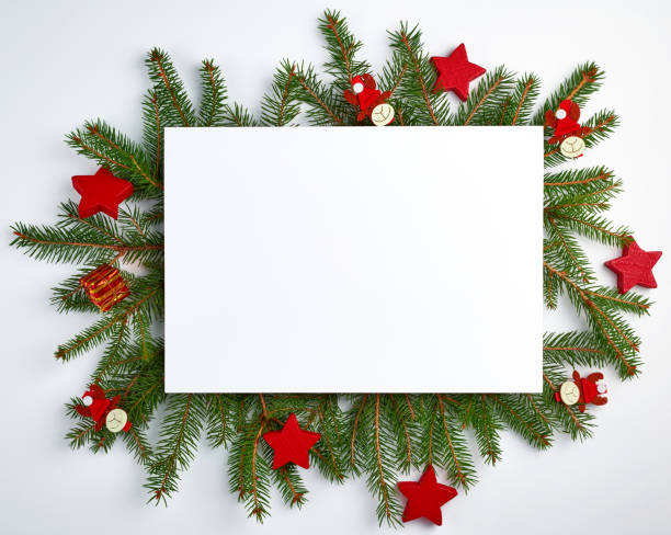istock congratulatory Christmas background with an empty white sheet and green branches of spruce 1175997792
