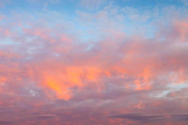 modèles colorés de nuage sur un ciel de coucher du soleil avec la lumière dramatique et vive - la folie douce photos et images de collection