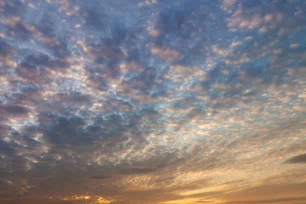 modèles colorés de nuage sur un ciel de coucher du soleil avec la lumière dramatique et vive - la folie douce photos et images de collection