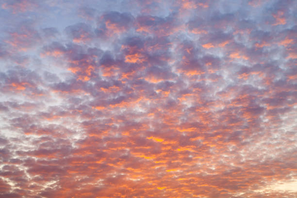 modèles colorés de nuage sur un ciel de coucher du soleil avec la lumière dramatique et vive - la folie douce photos et images de collection