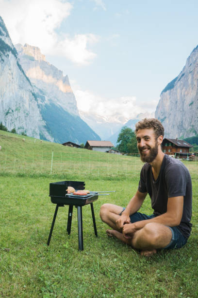 istock Man grilling burger in camping in Swiss Alps 1176001487