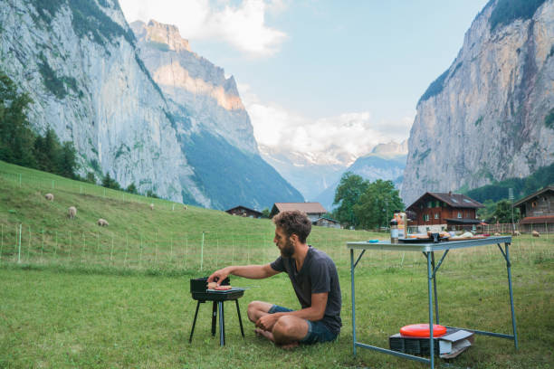 istock Man grilling burger in camping in Swiss Alps 1176001497