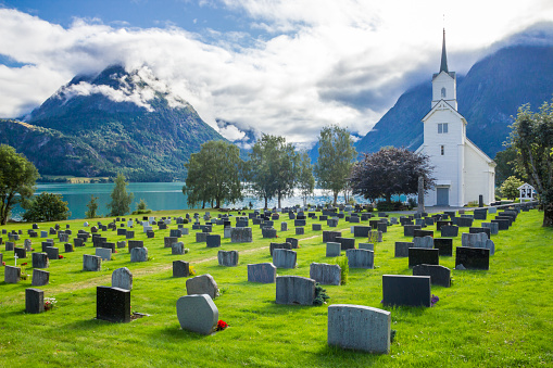 clouds over cemetery and church on the fjord in Norway