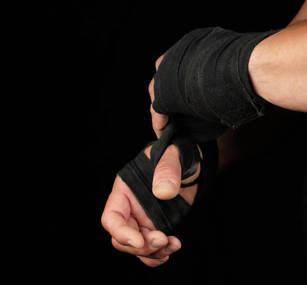 istock man wraps his hands in black textile bandage for sports 1176006498